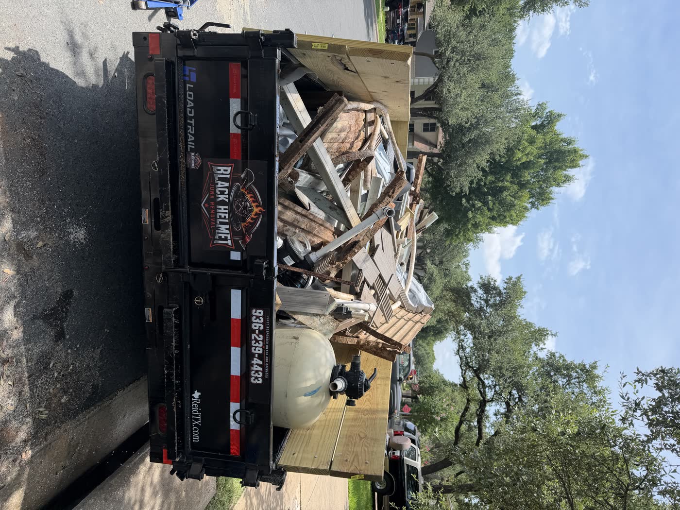 Black Helmet Junk Removal trailer loaded with hauled debris
